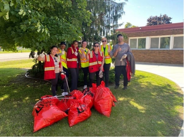 group of people standing in front of bags of garbage